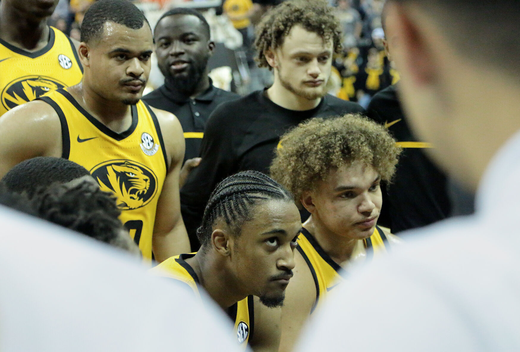 Starters huddle during a timeout to listen to head coach Dennis Gates